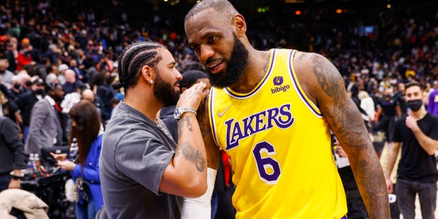 LeBron James #6 of the Los Angeles Lakers talks to rapper Drake after a game against the Toronto Raptors at Scotiabank Arena in Toronto, Ontario, Canada, March 18, 2022. 