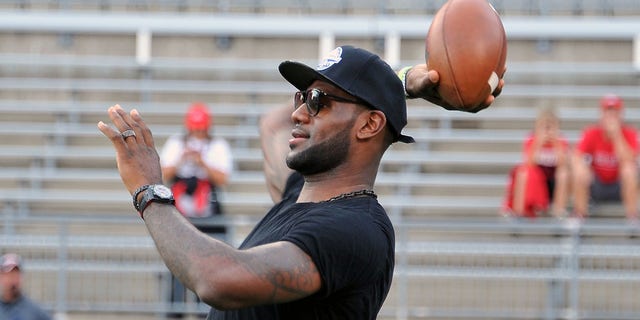 LeBron James throws a football before a game between the Wisconsin Badgers and the Ohio State Buckeyes on September 28, 2013 at Ohio Stadium in Columbus, Ohio.