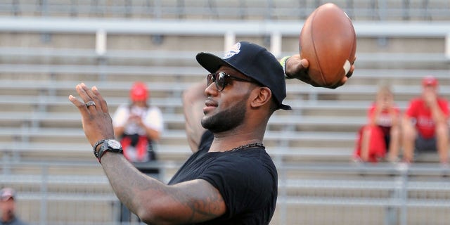 LeBron James throws a football prior to a game between the Wisconsin Badgers and the Ohio State Buckeyes at Ohio Stadium on Sept. 28, 2013 in Columbus, Ohio.