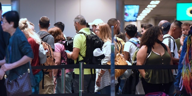 Travelers make their way through a TSA screening line at Orlando International Airport ahead of the July 4 holiday. 