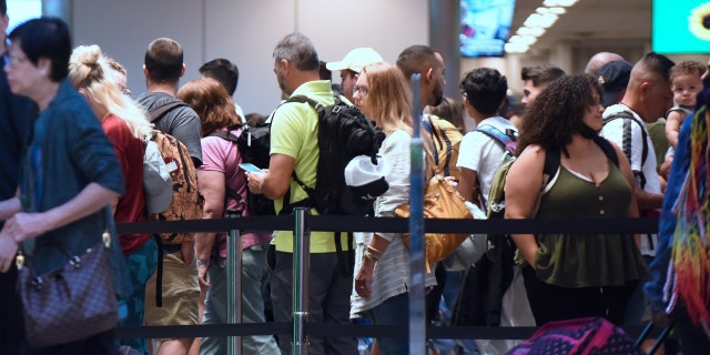 Travelers make their way through a TSA screening line at Orlando International Airport ahead of the July 4 holiday.