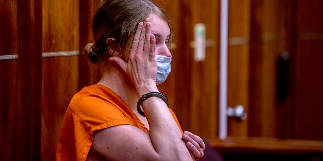 Courtney Clenney covers her face during an evidentiary hearing.