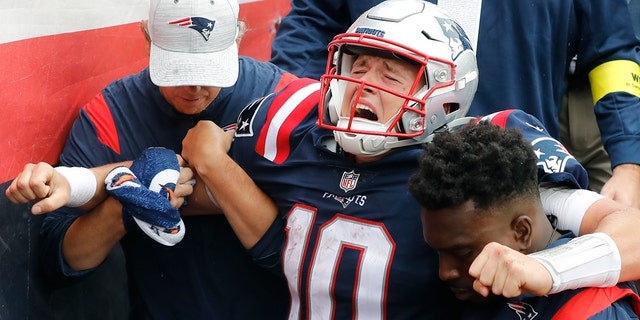 Quarterback Mac Jones of the New England Patriots is helped off the field during the fourth quarter against the Baltimore Ravens at Gillette Stadium on Sept. 25, 2022, in Foxborough, Massachusetts.