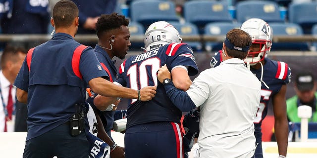 Quarterback Mac Jones of the New England Patriots is helped off the field during the fourth quarter against the Baltimore Ravens at Gillette Stadium on Sept. 25, 2022, in Foxborough, Massachusetts.
