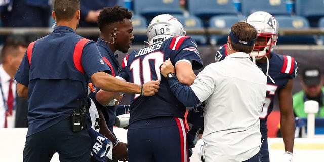 New England Patriots quarterback Mac Jones is helped off the field during the fourth quarter against the Baltimore Ravens at Gillette Stadium on September 25, 2022 in Foxborough, Massachusetts.