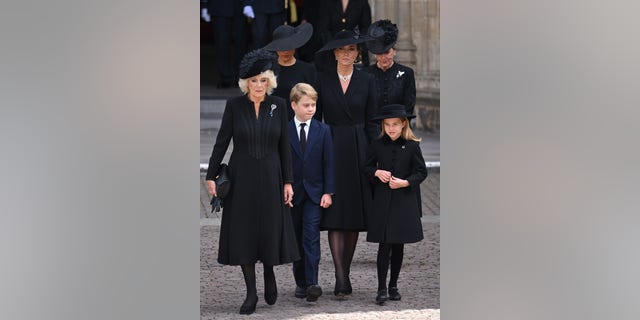 Queen Consort Camilla, left, walks with Meghan Markle, Prince George, Kate Middleton, Princess Charlotte and Sophie, Countess of Wessex, during the state funeral of Queen Elizabeth II at Westminster Abbey.