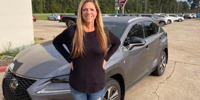 Missing Texas teacher Michelle Reynolds standing in front of her gray Lexus SUV. She was last heard from Thursday, and her car was located in New Orleans.