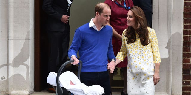 Prince William carries his newly-born daughter, his second child, in a car seat as he walks with Kate from the Lindo Wing at St. Mary's Hospital in central London on May 2, 2015.