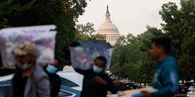 Volunteers and immigrants distribute supplies near the U.S. Capitol after immigrants arrived in Washington, D.C., on Aug. 26, 2022.