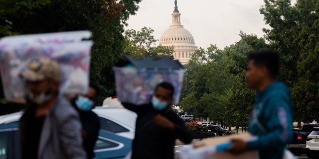 Volunteers and immigrants distribute supplies near the U.S. Capitol after immigrants arrived in Washington, D.C., on Aug. 26, 2022.