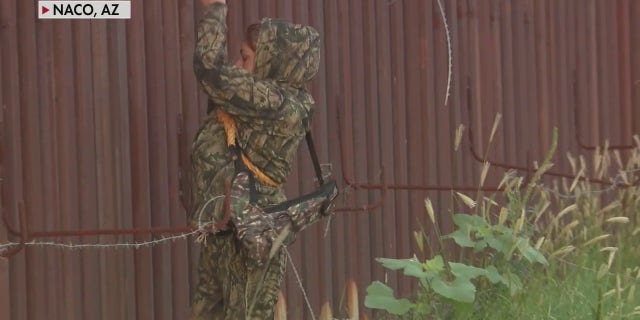 A migrant was lowered from a border wall in Naco, Arizona, by a human smuggler, in exclusive Fox News video.