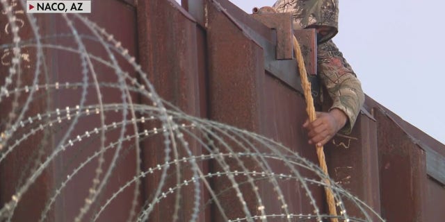 A human smuggler lowered a migrant from a border wall in Naco, Arizona, in exclusive Fox News video.
