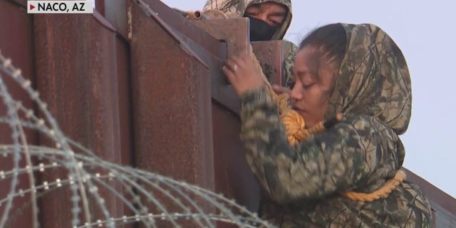 A migrant was lowered from a border wall in Naco, Arizona, by a human smuggler, in exclusive Fox News video.