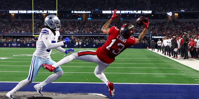 Mike Evans #13 of the Tampa Bay Buccaneers scores a touchdown ahead of Trevon Diggs #7 of the Dallas Cowboys during the second half at AT&T Stadium on September 11, 2022, in Arlington, Texas.