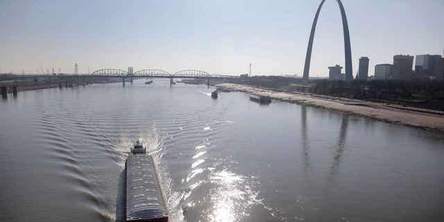 A barge works its way up the Mississippi River in St. Louis. Parts of the river are low from weeks of drought. Barge traffic is being limited because of the water levels as crop harvests begin for the 2022 season. 