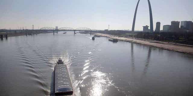 A barge works its way up the Mississippi River in St. Louis. Parts of the river are low from weeks of drought. Barge traffic is being limited because of the water levels as crop harvests begin for the 2022 season.