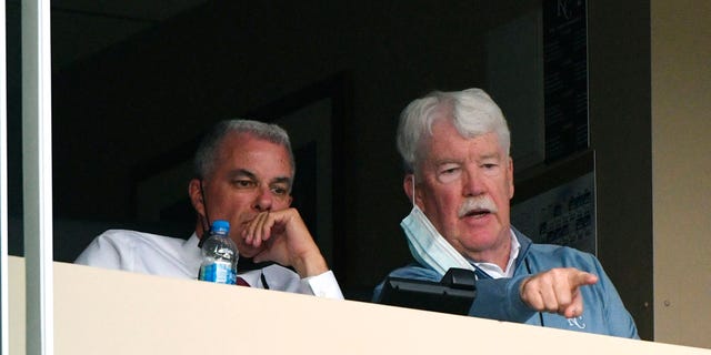 General manager Dayton Moore (L) and owner John Sherman of the Kansas City Royals watch a game against the Milwaukee Brewers in the first inning at Kauffman Stadium on May 18, 2021 in Kansas City, Missouri.
