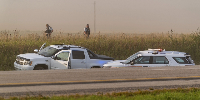 Police and investigators gather at the scene where stabbing suspect Myles Sanderson was tracked down in Rosthern, Saskatchewan on Wednesday, Sept. 7.