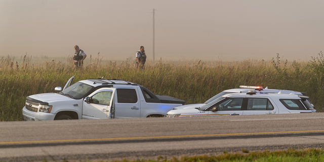 Police and investigators gather at the scene where stabbing suspect Myles Sanderson was tracked down in Rosthern, Saskatchewan on Wednesday, Sept. 7.