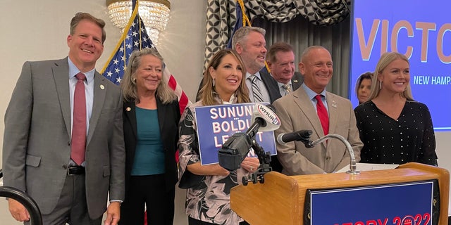 New Hampshire Gov. Chris Sununu, left, Republican National Committee chair Ronna McDaniel, center, and Republican Senate nominee Don Bolduc, second from right, are shown at a New Hampshire GOP unity breakfast in Concord, New Hampshire, on Sept. 15, 2022.
