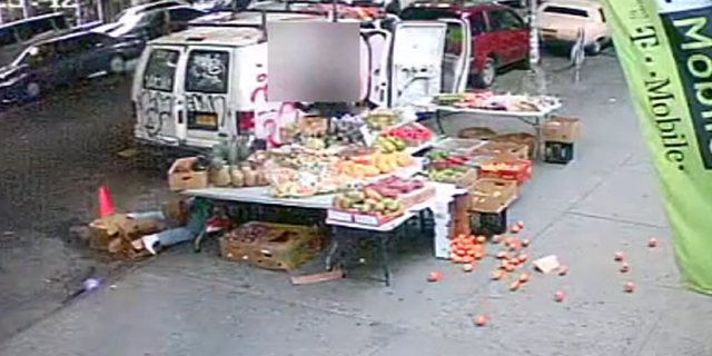 The suspect and victim then crash into the fruit stand, sending items tumbling to the ground.