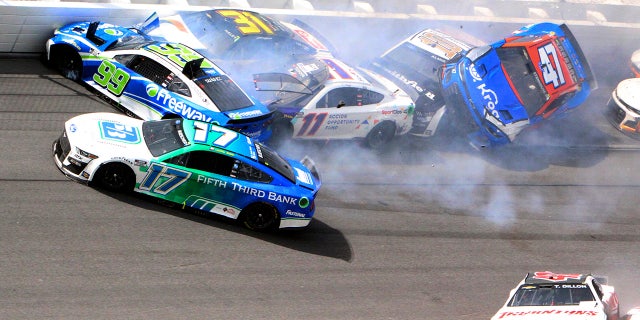 Chris Buescher (17), Daniel Suarez (99), Denny Hamlin (11), Justin Haley (31), Ty Dillon (42), Aric Almirola (10) and Ricky Stenhouse Jr. (47) are involved in a multi-car accident between turns 1 and 2 during a NASCAR Cup Series auto race at Daytona International Speedway, Sunday, Aug. 28, 2022, in Daytona Beach, Fla.