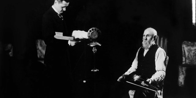 Very early Grand Ole Opry broadcast from 1925 when it was still WSM's "Barn Dance." The "Solemn Old Judge" George D. Hay, left, is at the microphone with a whistle while Uncle Jimmy Thompson is seated with a fiddle. A performance by the elderly fiddler inspired a hugely positive response from listeners.