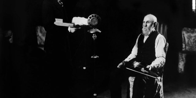 Very early Grand Ole Opry broadcast from 1925 when it was still WSM's "Barn Dance." The "Solemn Old Judge" George D. Hay, left, is at the microphone with a whistle while Uncle Jimmy Thompson is seated with a fiddle. A performance by the elderly fiddler inspired a hugely positive response from listeners.