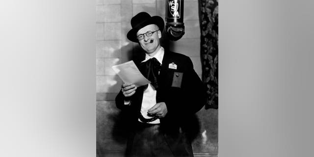 Grand Ole Opry founder George D. Hay, signature whistle under his arm, is pictured with the WSM microphone hanging near his head.