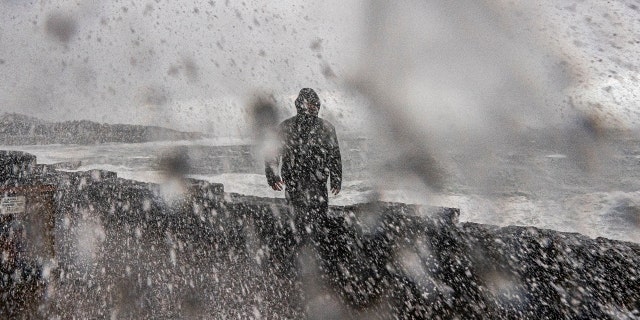 Storm surge hits Randy Evans as a bomb cyclone system moves over the Northwest United States on Oct. 24, 2021, in Depoe Bay, Oregon.