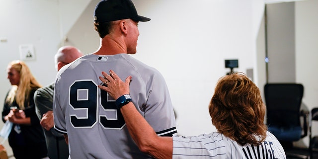Aaron Judge, #99 of the New York Yankees, stands with his mother, Patty, after defeating the Toronto Blue Jays and tying Roger Maris AL home run record at Rogers Centre on Wednesday, Sept. 28, 2022 in Toronto.