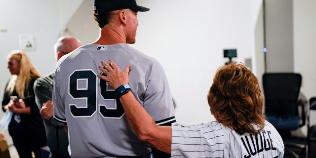 Aaron Judge, #99 of the New York Yankees, stands with his mother, Patty, after defeating the Toronto Blue Jays and tying Roger Maris AL home run record at Rogers Centre on Wednesday, Sept. 28, 2022 in Toronto.