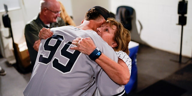 Aaron Judge #99 of the New York Yankees hugs his mother.