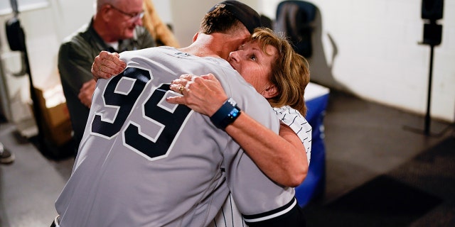 Aaron Judge, #99 of the New York Yankees, hugs his mother.