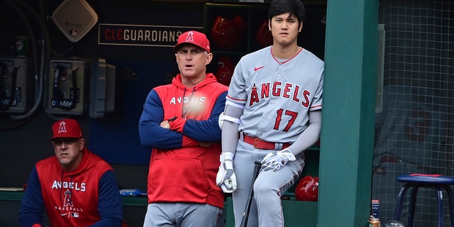 Los Angeles Angels interim manager Phil Nevin, left, and Shohei Ohtani stand in the dugout during the first inning of the team's baseball game against the Cleveland Guardians, Tuesday, Sept. 13, 2022, in Cleveland. 