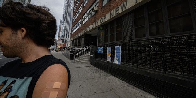A man, who wished to remain anonymous, displays his arm where he received a polio vaccination, outside a health clinic in Brooklyn, New York on August 17, 2022. 