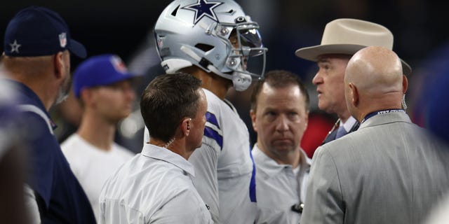 Dak Prescott, #4 of the Dallas Cowboys, has his hand examined by team surgeon Dr. Dan Cooper during the second half of the game against the Tampa Bay Buccaneers at AT&T Stadium on Sept. 11, 2022 in Arlington, Texas.