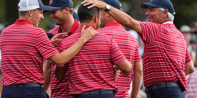 USA team members congratulate Xander Schauffele, center, on the 18th green after Schauffele won the hole and match during their singles match at the Presidents Cup golf tournament at the Quail Hollow Club, Sunday, Sept. 25, 2022, in Charlotte, N.C. Team USA won the Presidents Cup golf tournament.
