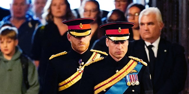 Queen Elizabeth II's grandchildren, Prince Harry, Duke of Sussex, left, and Prince William, Prince of Wales, arrive to hold a vigil around Queen Elizabeth II's coffin in Westminster Hall.