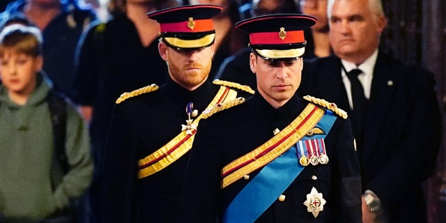 Queen Elizabeth II 's grandchildren (L-R) Britain's Prince Harry, Duke of Sussex (L) and Britain's Prince William, Prince of Wales (R) arrive to hold a vigil around the coffin of Queen Elizabeth II, in Westminster Hall.