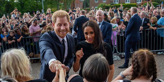 Prince Harry and Meghan greet well-wishers outside Windsor Castle.