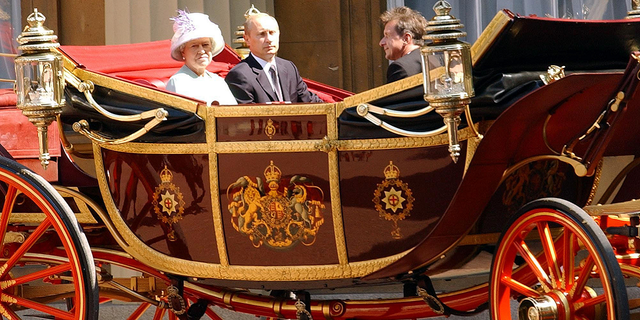 Russian President Vladimir Putin and Queen Elizabeth enter Buckingham Palace in a horse-drawn carriage on June 24, 2003.