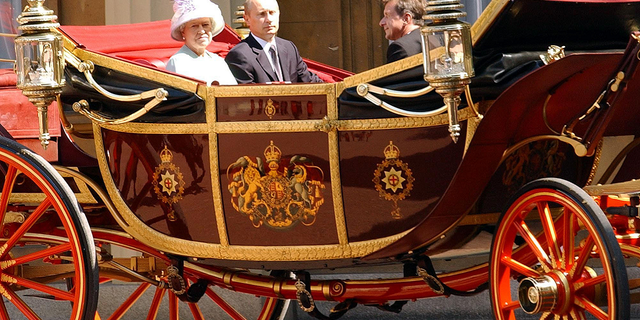 Russian President Vladimir Putin and Queen Elizabeth enter Buckingham Palace in a horse-drawn carriage on June 24, 2003.