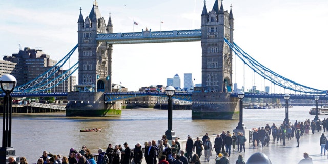 Members of the public line up Saturday, Sept. 17, 2022, near Tower Bridge as they wait to view Queen Elizabeth II lying in state ahead of her funeral on Monday in London.