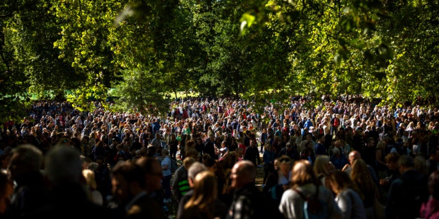 People gather to bring flowers for Queen Elizabeth II at Green Park, near Buckingham Palace in London, Saturday, Sept. 17, 2022.  