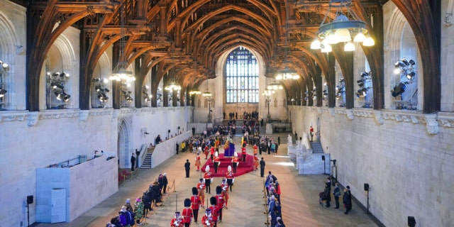 The guard is changed while members of the public file past the coffin of Queen Elizabeth II in Westminster Hall at the Palace of Westminster in London Saturday, Sept. 17, 2022. 