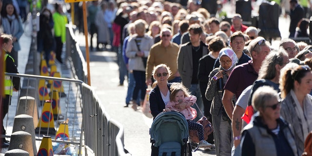 People queue to see the coffin of Queen Elizabeth II as she lies at rest at St. Giles Cathedral in Edinburgh, Scotland, Tuesday, Sept. 13, 2022.