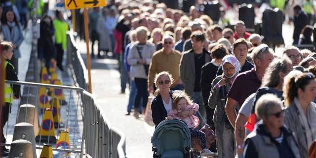 People queue to see the coffin of Queen Elizabeth II as she lies at rest at St. Giles Cathedral in Edinburgh, Scotland, Tuesday, Sept. 13, 2022.