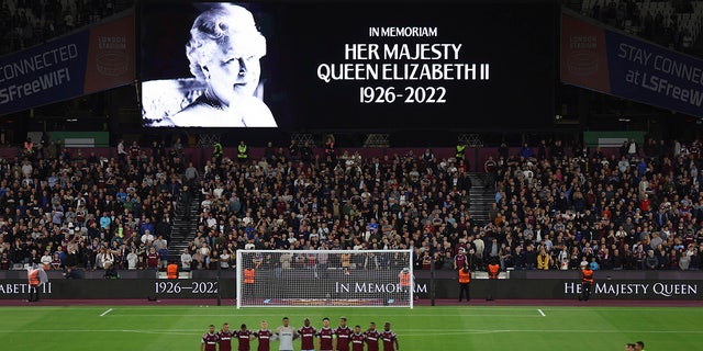 Team players stand on the pitch during minutes silence following the death of Queen Elizabeth II prior the Group B Europa Conference League soccer match between West Ham and FCSB Steaua Bucharest at London Stadium in London, Thursday, Sept. 8, 2022.