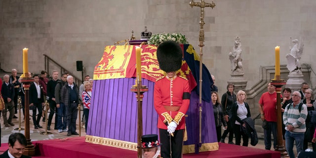 Members of the public file past the coffin of Queen Elizabeth II, draped in the Royal Standard with the Imperial State Crown and the Sovereign's orb and scepter, lying in state on the catafalque, in Westminster Hall, at the Palace of Westminster, in London, Friday, Sept. 16, 2022, ahead of her funeral on Monday. 